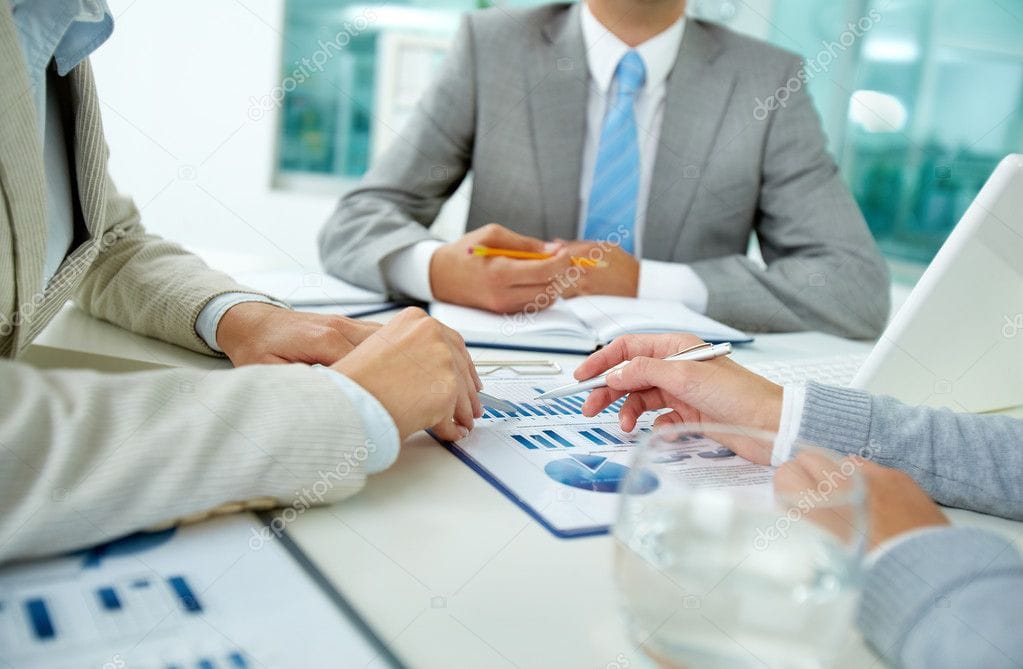 Business professionals discussing employee benefits and insurance options at a meeting.