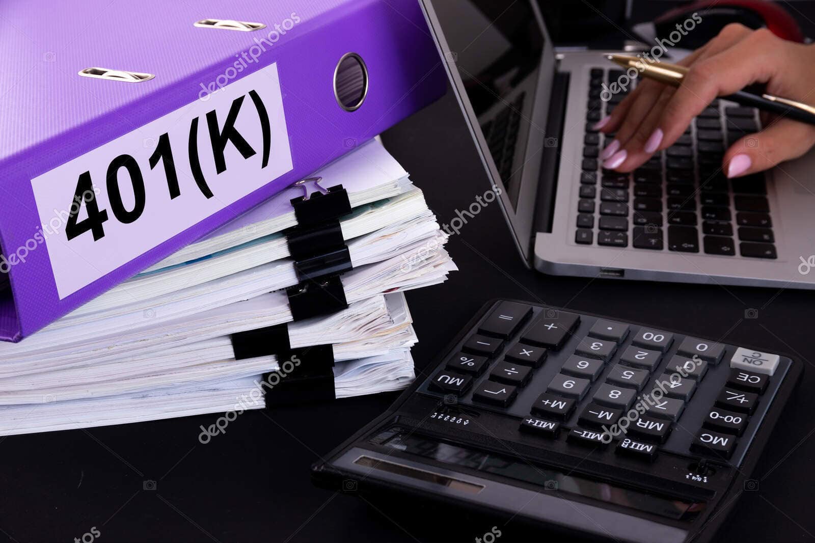 Folder labeled 401(K) with financial documents and calculator on desk.