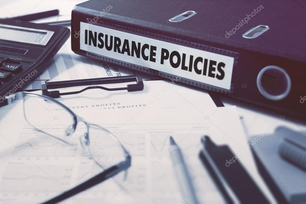 Insurance policies binder with office supplies and documents.